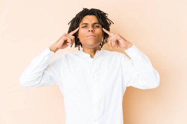 Genç Afrikalı Amerikalı Rasta adam bir işe odaklanmış, parmaklarını işaret ediyor..