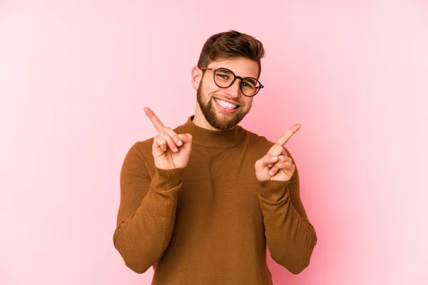 Young Caucasian Man Isolated Pink Background Pointing Different Copy Spaces — Stock Photo, Image