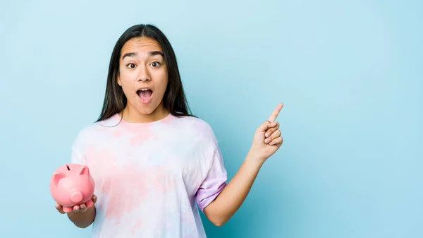 Joven Asiática Sosteniendo Banco Rosa Sobre Fondo Aislado Apuntando Hacia — Foto de Stock