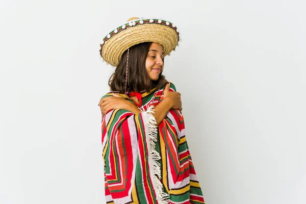Young mexican woman isolated on white background hugs, smiling carefree and happy.