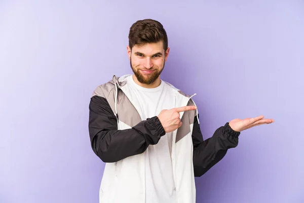 Young Man Isolated Purple Background Excited Holding Copy Space Palm — Stock Photo, Image