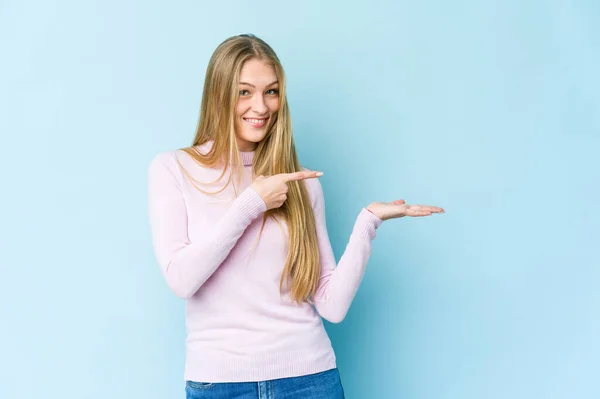 Junge Blonde Frau Isoliert Auf Blauem Hintergrund Aufgeregt Hält Eine — Stockfoto