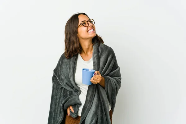 Young latin woman with blanket isolated on white background relaxed and happy laughing, neck stretched showing teeth.