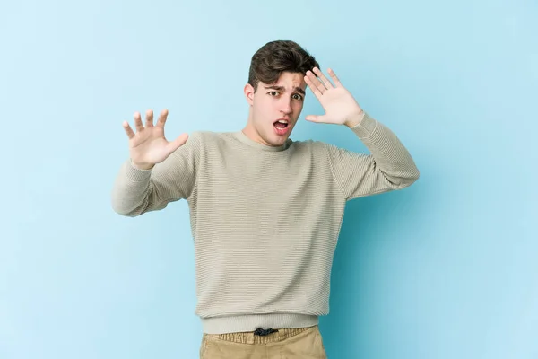 Jovem Caucasiano Isolado Fundo Azul Sendo Chocado Devido Perigo Iminente — Fotografia de Stock