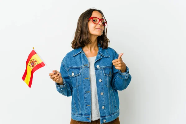 Young spanish woman holding a flag isolated on white background touches tummy, smiles gently, eating and satisfaction concept.