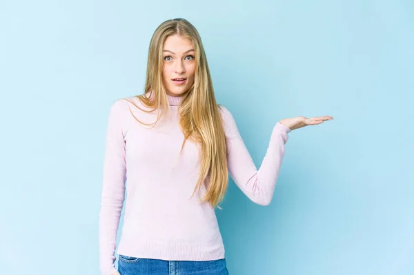 Giovane Donna Bionda Isolata Sfondo Blu Impressionato Tenendo Spazio Copia — Foto Stock