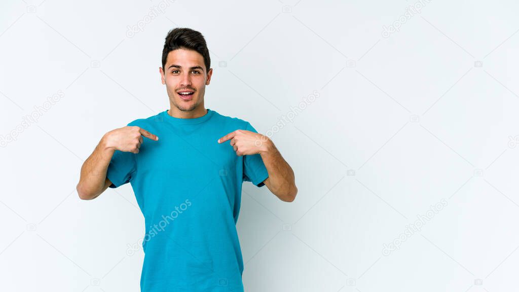 Young caucasian man isolated on white background surprised pointing with finger, smiling broadly.