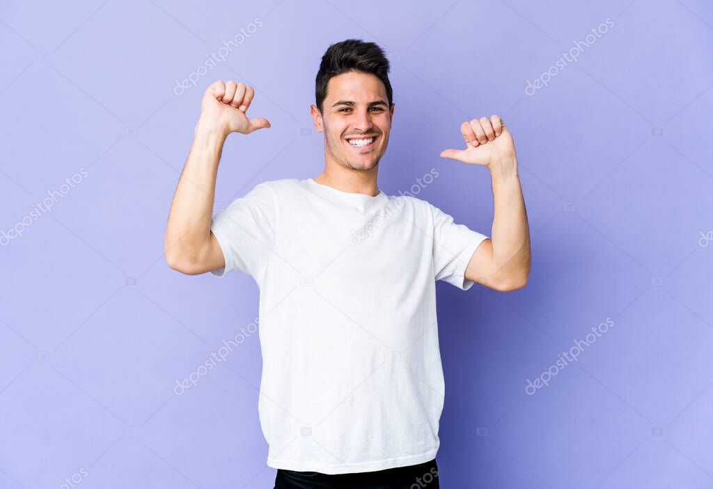 Young caucasian man isolated on purple background feels proud and self confident, example to follow.