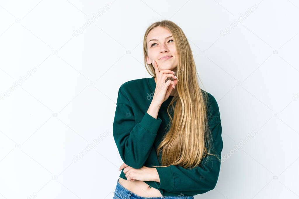 Young blonde woman isolated on white background relaxed thinking about something looking at a copy space.