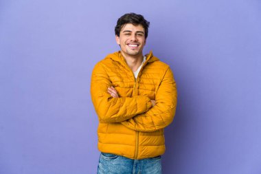 Kendine güveni tam, kararlılıkla kollarını kavuşturan genç havalı bir adam..