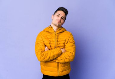 Mor arka planda izole edilmiş, sıkılmış, yorgun ve dinlenmeye ihtiyacı olan genç beyaz bir adam..