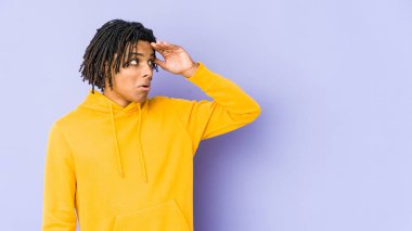 Genç Afro-Amerikan Rasta adam uzaklara bakıyor ve elini alnına koyuyor..