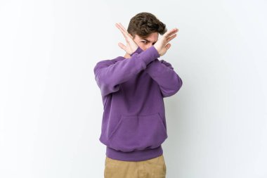 Beyaz arka planda izole genç beyaz adam iki kolu çapraz tutuyor, inkar kavramı.