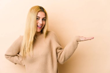 Sarışın, beyaz bir kadın avucunun içinde fotokopi odası gösteriyor ve başka bir eli belinde tutuyor..