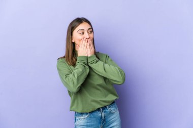 Kafkasyalı genç bir kadın bir şeye gülüyor, elleriyle ağzını kapatıyor..