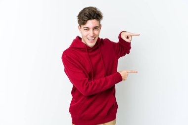 Beyaz arka planda izole edilmiş genç beyaz bir adam işaret parmağıyla işaret ettiği için heyecanlı..