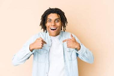 Genç Afro-Amerikan Rasta adamı parmağını gösterip, gülümseyerek şaşırdı..