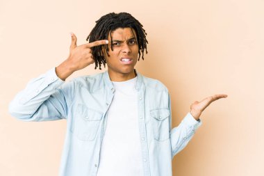 Genç Afro-Amerikan Rasta Adam elinde bir ürünü tutuyor ve gösteriyor..