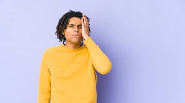 Rasta saç stili giyen genç siyahi adam yorgun ve uykulu ellerini başının üstünde tutuyor..