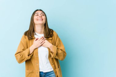 Genç beyaz kadın gülüyor, ellerini kalbe koyuyor, mutluluk kavramı..