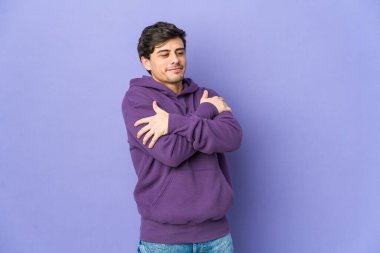 Genç havalı adam sarılıyor, kaygısız ve mutlu gülümsüyor..