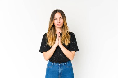 Beyaz arka planda izole edilmiş genç beyaz kadın dua ediyor, bağlılık gösteriyor, dindar biri ilahi ilhamı arıyor..