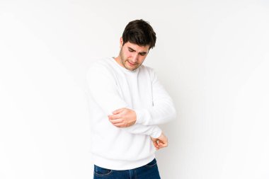 Genç adam beyaz arka planda izole edilmiş dirsek masajı yapıyor, kötü bir hareketin ardından acı çekiyor..