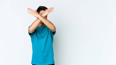 Beyaz arka planda izole genç beyaz adam iki kolu çapraz tutuyor, inkar kavramı.