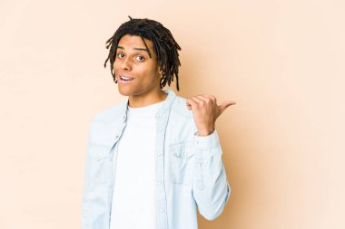 Genç Afro-Amerikan Rasta adamı parmağıyla işaret ediyor, gülüyor ve kaygısız..