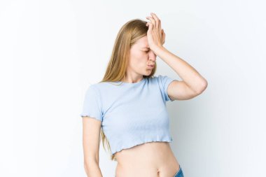 Beyaz arka planda izole edilmiş genç sarışın bir kadın bir şeyi unutuyor. Alnına avuç içi ile vuruyor ve gözlerini kapıyor..