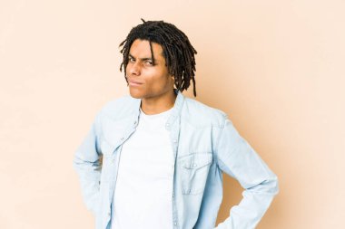 Afro-Amerikan Rasta 'lı genç adam hoşnutsuzca kaşlarını çatıyor, kollarını kavuşturuyor..