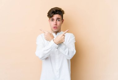 Beyazların arka plan noktalarında izole edilmiş genç beyaz adam iki seçenek arasında seçim yapmaya çalışıyor..