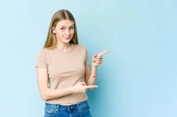 Mujer Rubia Joven Aislada Sobre Fondo Azul Impactado Señalando Con —  Fotos de Stock