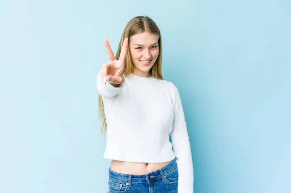 Jovem Loira Isolada Fundo Azul Mostrando Sinal Vitória Sorrindo Amplamente — Fotografia de Stock