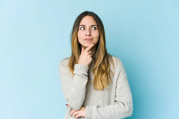 Ung Kaukasisk Kvinna Isolerad Blå Bakgrund Tittar Sidled Med Tveksamma — Stockfoto