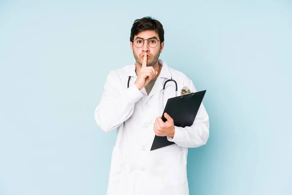 Νεαρός Γιατρός Απομονωμένος Μπλε Φόντο Κρατώντας Ένα Μυστικό Ζητώντας Σιωπή — Φωτογραφία Αρχείου