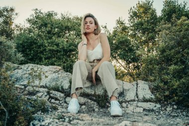 Doğada turuncu ve yeşil çiçekli sarışın güzel bir kız..