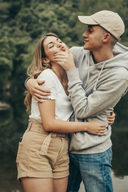 Erkek arkadaş ve kız arkadaş yazın bir gölün ortasında birbirlerini şımartıyorlar..