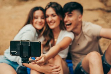 Arkadaşlar doğada sarılırken fotoğraf çekiyorlar..