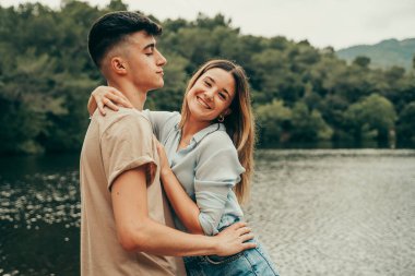 20 yaşında bir çift güzel bir yaz gününde gölde sarılıyor..