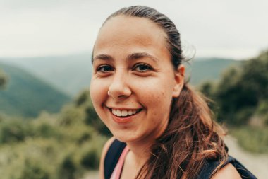 Yürüyüşçü doğadaki dağın tepesindeki haritaya bakıyor..