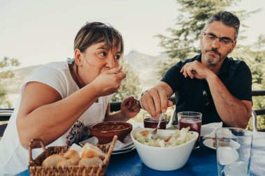 50 yaşında yetişkin bir çift açık hava pikniğinde yemek yiyor..