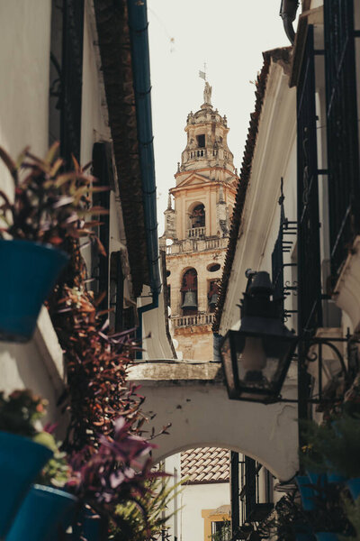 Church steeple tower covered by flowers in Cordoba, Spain.