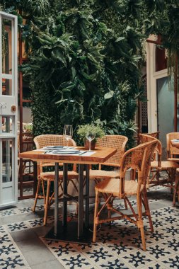 Modern bir bahçede iki kişilik boş bir restoran masası..