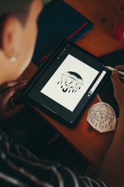 Profesyonel dövme sanatçısı atölyesindeki grafik tabletine bir çizim yapıyor..