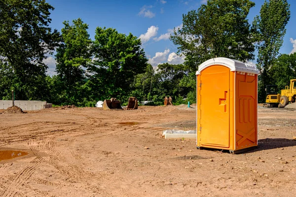 Porta Potty Sitio Construcción Activo Con Equipos Movimiento Tierra Fondo —  Fotos de Stock