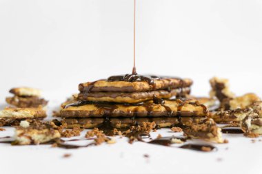 Bisküviler ve erimiş çikolatalar beyaz arka planda