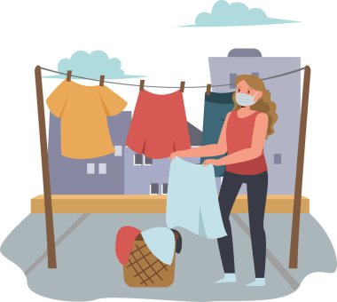 Kadın tıbbi maske kullanırken çamaşırlarını dışarı asıyor.