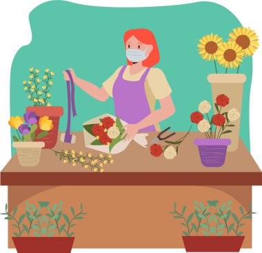 Çiçekçi çiçek kovası yaparken tıbbi maske takıyor.