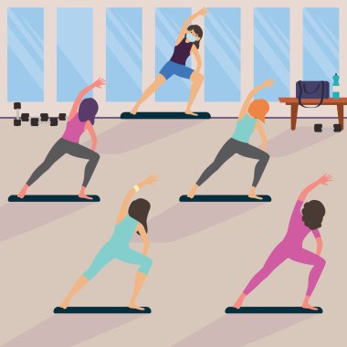 Kadınlar yoga dersinde yoga yaparken mesafelerini koruyorlar.